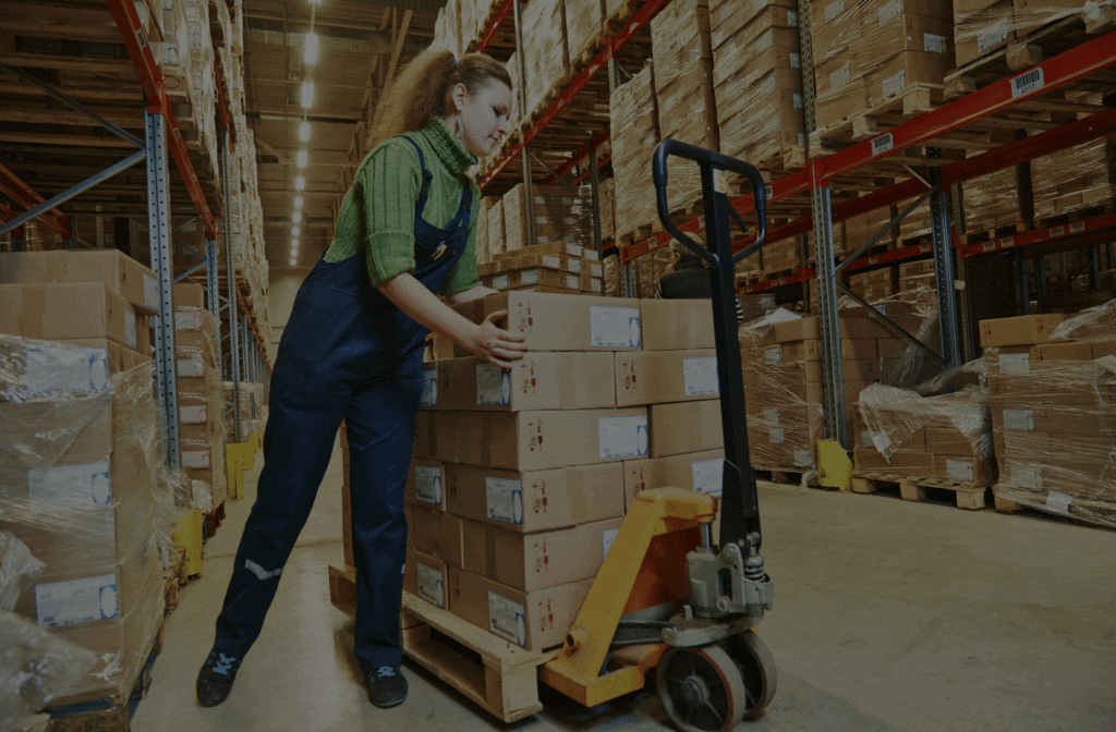 Warehouse employee stacking boxes on pallet jack