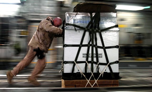 Man pushing a heavy stack of cargo