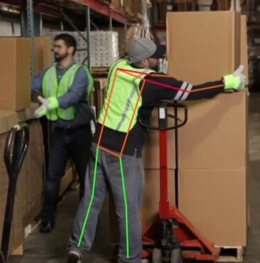 Two men loading big boxes onto pallet jacks in warehouse