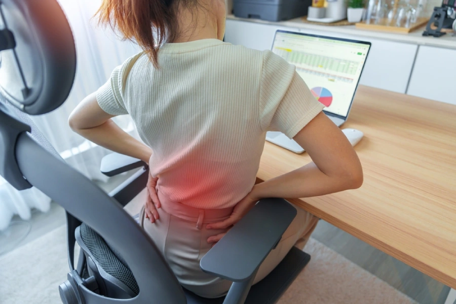 Woman having back body pain during work long time on workplace