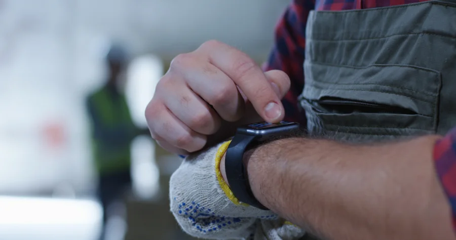 Closeup of warehouse worker using a smartwatch to monitor vitals