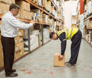 Ergonomics specialist conducting a job analysis to document the physical demands of an industrial role.